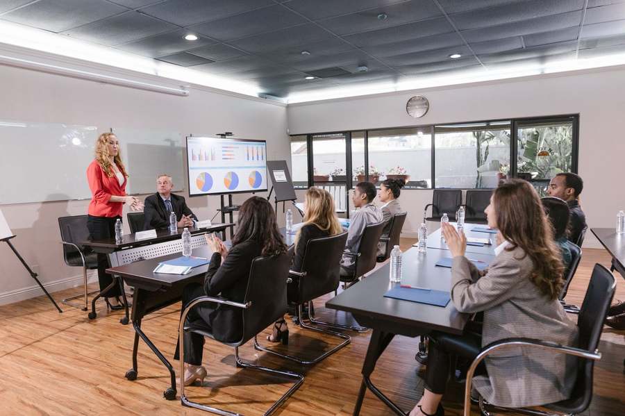 Femme conduisant une présentation stratégique devant un groupe.