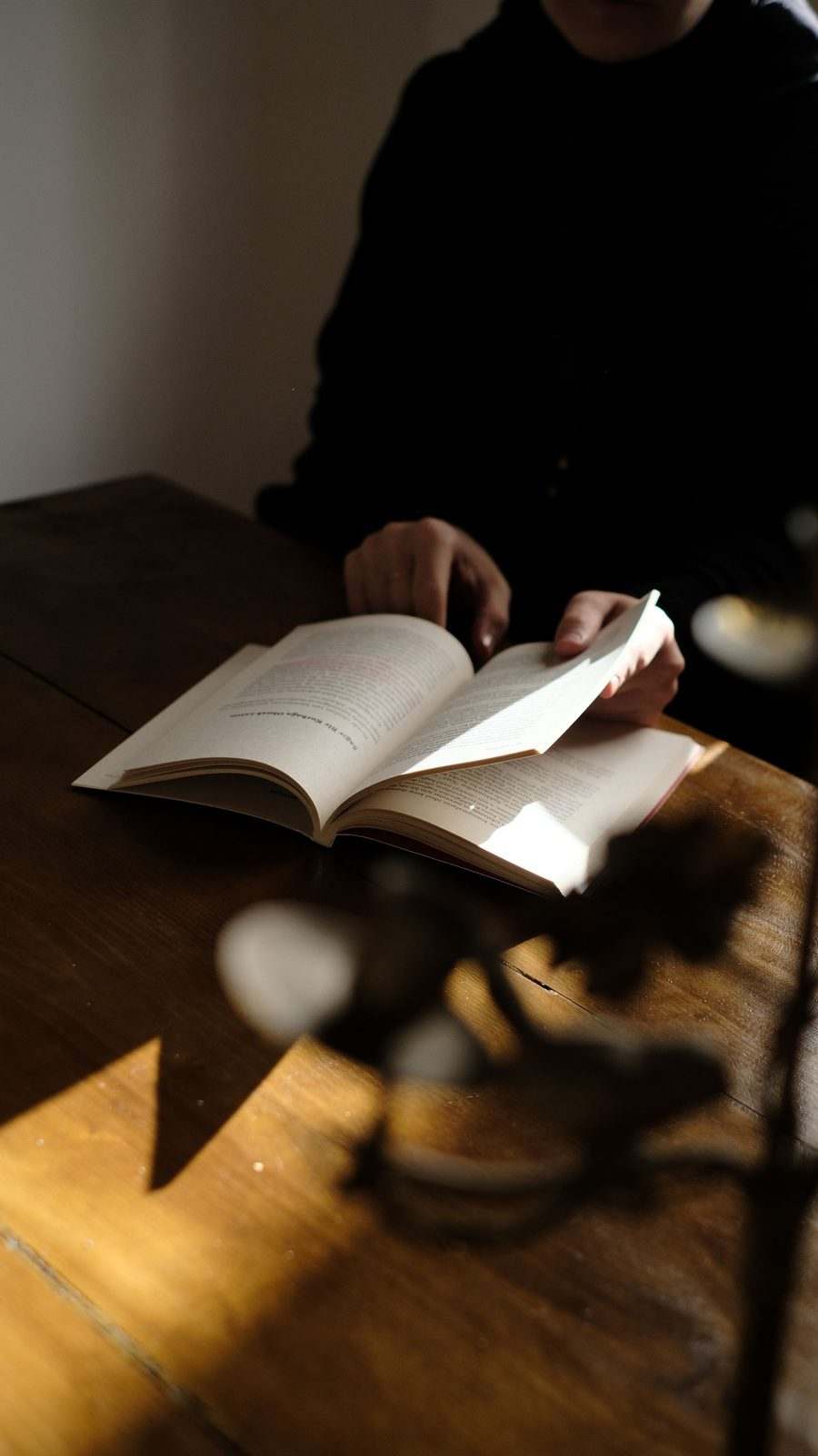 Lecture silencieuse sous une lumière douce, illustrant la réflexion et le calme.