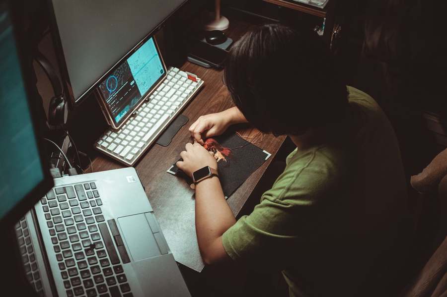 Personne analysant avec attention un travail créatif dans son espace de travail.